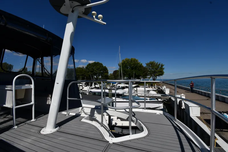 Slide: The Image of 2000 Mainship 390 Trawler docked at marina, clear blue sky, waterfront view. - 13