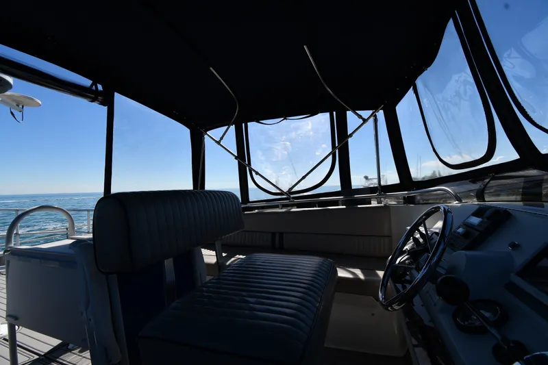 Slide: The Image of Interior view of 2000 Mainship 390 Trawler helm with ocean backdrop. - 20