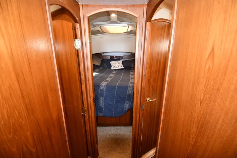 Slide: The Image of Cozy cabin interior of 2000 Mainship 390 Trawler with wooden finish and comfortable bedding. - 25