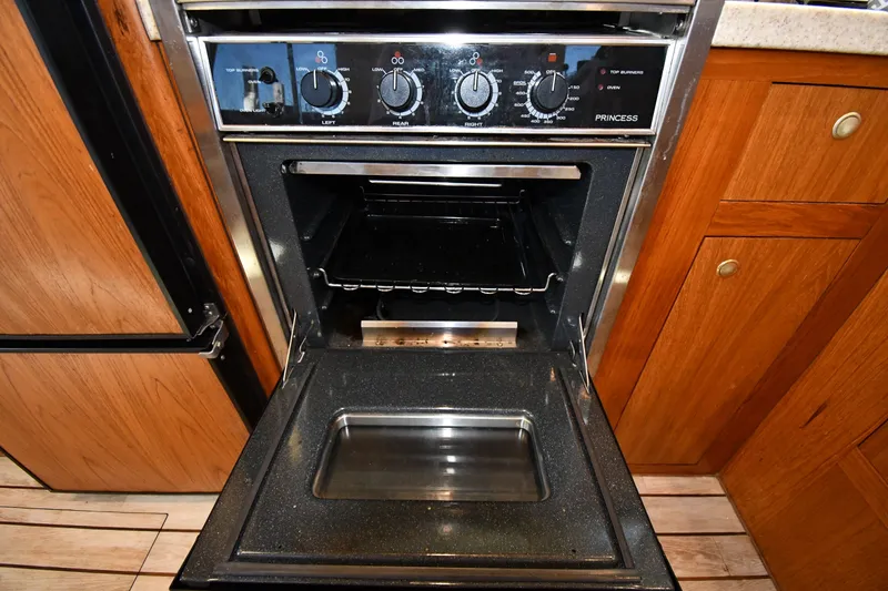 Slide: The Image of Open oven in Mainship 390 Trawler, 2000 model, with wooden cabinetry. - 43