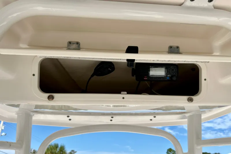 Slide: The Image of 2024 Robalo R222 Center Console storage compartment with radio equipment. - 15