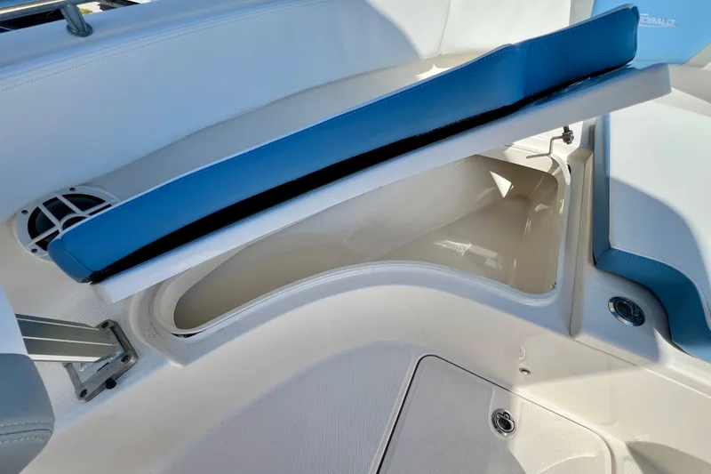 Slide: The Image of 2024 Robalo R222 Center Console boat storage compartment with blue cushioned seat. - 17