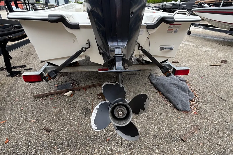 Slide: The Image of Rear view of a 2021 Mako Pro Skiff 17 CC boat with visible propeller and trailer. - 12