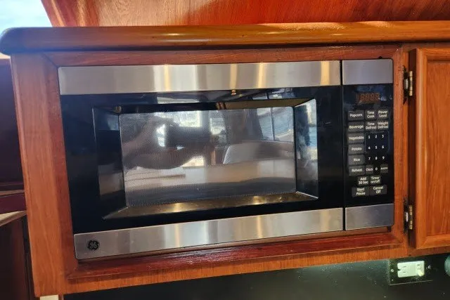 Slide: The Image of Microwave in 1987 Ocean Yachts 48 Super Sport kitchen, set in wooden cabinetry. - 19