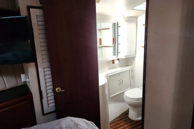 Slide: The Image of Interior view of 1987 Ocean Yachts 48 Super Sport bathroom with wooden accents. - 25