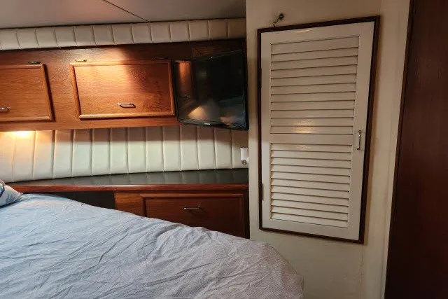 Slide: The Image of 1987 Ocean Yachts 48 Super Sport cabin interior with wooden cabinets and bed. - 24