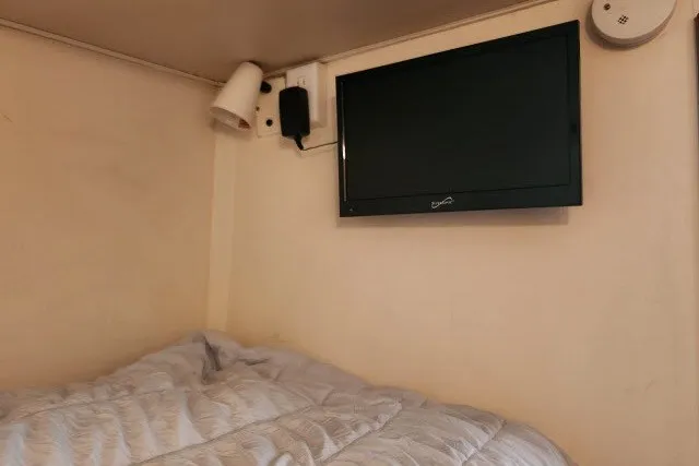 Slide: The Image of Cozy cabin interior of 1987 Ocean Yachts 48 Super Sport with bed and wall-mounted TV. - 32