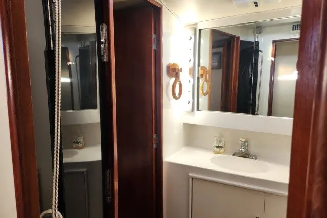 Slide: The Image of 1987 Ocean Yachts 48 Super Sport yacht bathroom with mirror, sink, and wooden accents. - 30