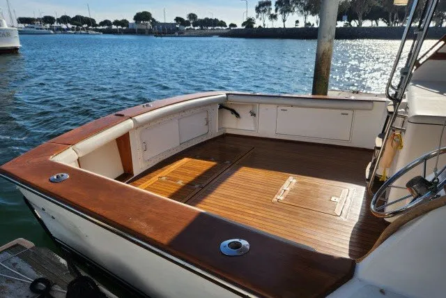 Slide: The Image of 1987 Ocean Yachts 48 Super Sport boat deck with wooden flooring, docked by the water. - 62