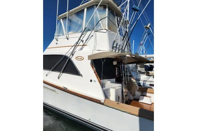 Slide: The Image of 1987 Ocean Yachts 48 Super Sport boat docked, featuring a flybridge and fishing equipment. - 58