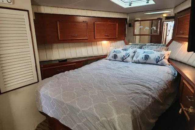 Slide: The Image of Cozy bedroom in 1987 Ocean Yachts 48 Super Sport with wood accents and nautical-themed pillows. - 23