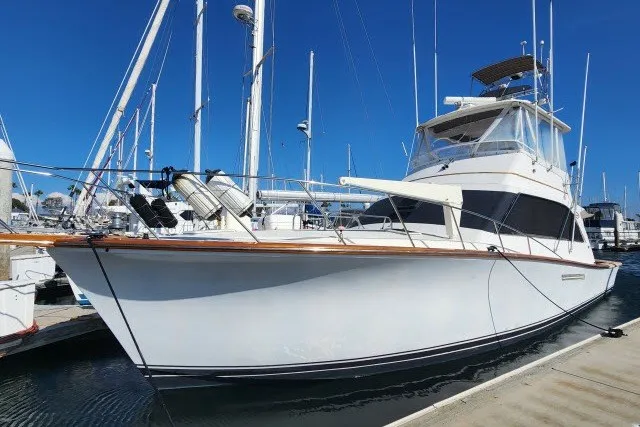 Slide: The Image of 1987 Ocean Yachts 48 Super Sport docked at marina under clear blue sky. - 57
