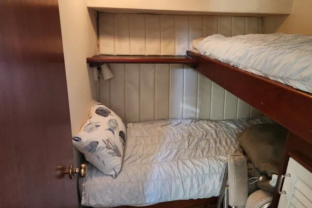 Slide: The Image of Bunk beds in 1987 Ocean Yachts 48 Super Sport cabin, featuring cozy bedding and wooden accents. - 31
