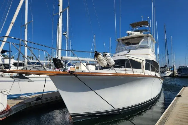 Slide: The Image of 1987 Ocean Yachts 48 Super Sport docked at marina under clear blue sky. - 56