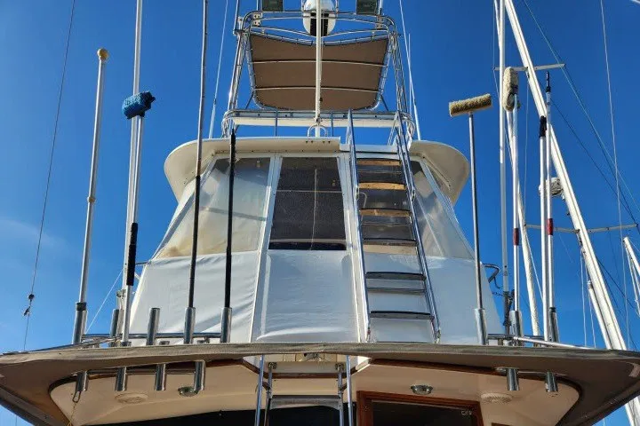 Slide: The Image of 1987 Ocean Yachts 48 Super Sport boat with ladder and canopy against blue sky. - 44