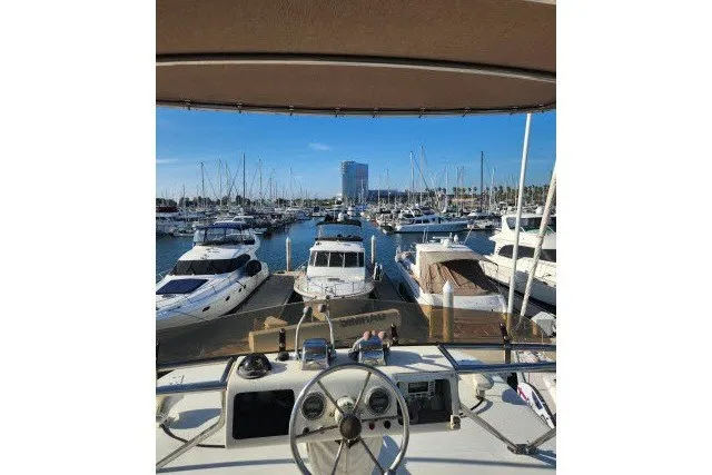 Slide: The Image of 1987 Ocean Yachts 48 Super Sport docked in a marina, surrounded by other boats. - 52