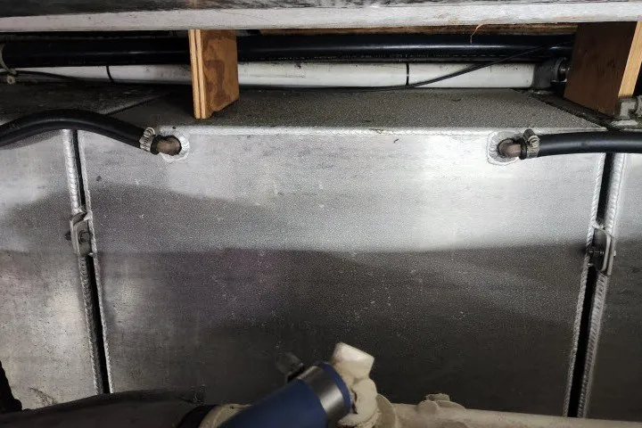 Slide: The Image of Engine compartment of a 1987 Ocean Yachts 48 Super Sport, showing metal panel and hoses. - 68