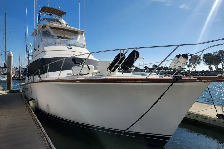 The Image of 1987 Ocean Yachts 48 Super Sport docked at marina under clear blue sky. - 1