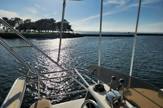 Slide: The Image of 1987 Ocean Yachts 48 Super Sport on serene water with scenic shoreline view. - 54