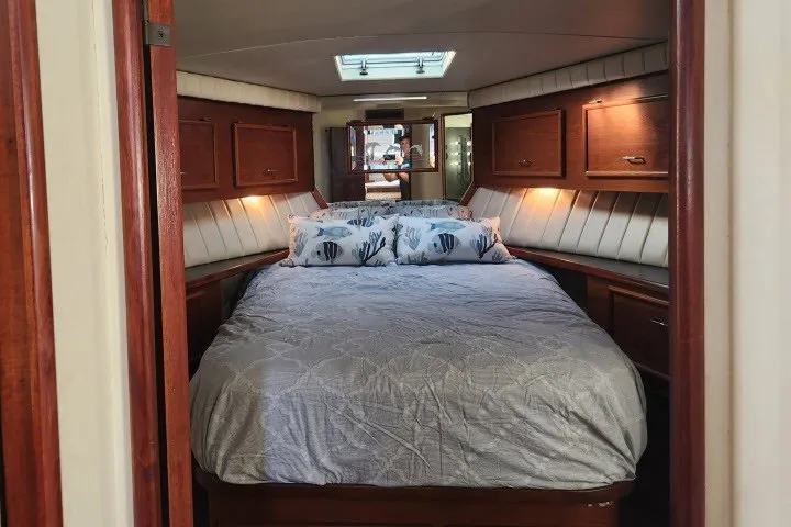 Slide: The Image of 1987 Ocean Yachts 48 Super Sport cabin with cozy bed and wooden cabinetry. - 22