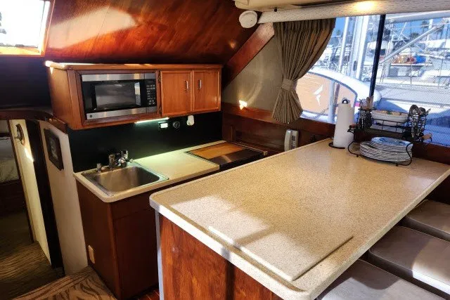 Slide: The Image of 1987 Ocean Yachts 48 Super Sport yacht kitchen with sink, microwave, and countertop. - 15
