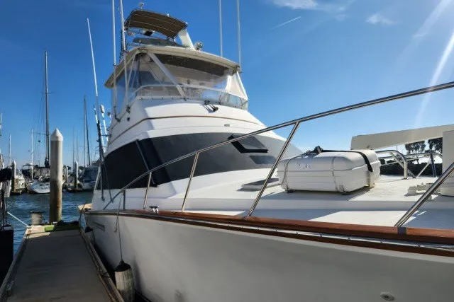 Slide: The Image of 1987 Ocean Yachts 48 Super Sport docked at marina under clear blue sky. - 60