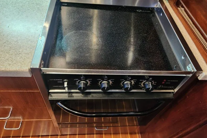 Slide: The Image of Stove and oven in 1987 Ocean Yachts 48 Super Sport kitchen, featuring control knobs and wooden flooring. - 18