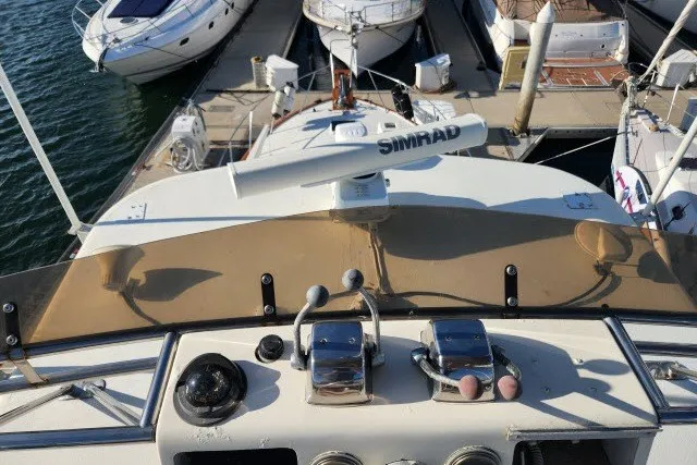 Slide: The Image of 1987 Ocean Yachts 48 Super Sport at marina, featuring helm controls and Simrad radar. - 53