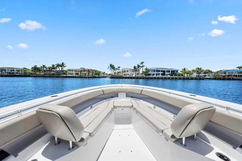 Slide: The Image of 2024 Sportsman Open 352 Center Console boat on calm water with luxury waterfront homes. - 32