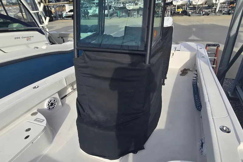 Slide: The Image of 2024 Caymas 281 HB boat with covered console, docked in a marina. - 46