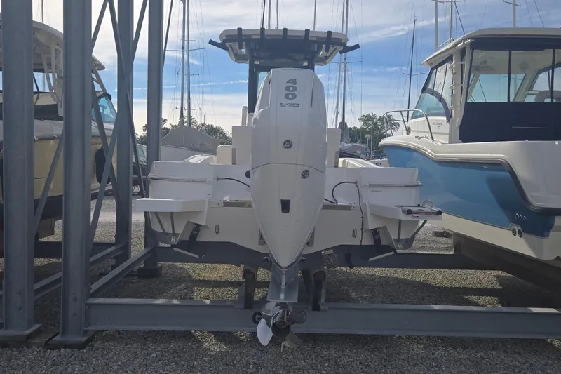 Slide: The Image of 2024 Caymas 281 HB boat with powerful outboard engine in a marina setting. - 10