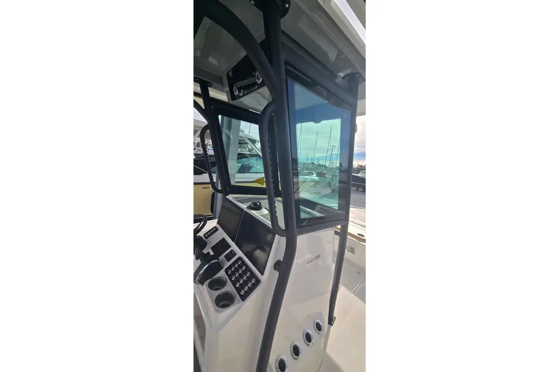 Slide: The Image of 2024 Caymas 281 HB boat console with modern controls and clear windshield. - 17