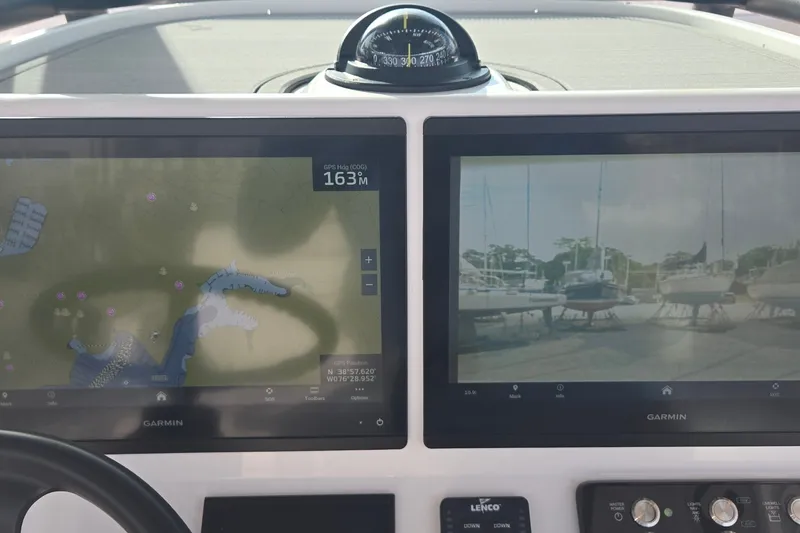 Slide: The Image of 2024 Caymas 281 HB boat dashboard with Garmin navigation displays and compass. - 18