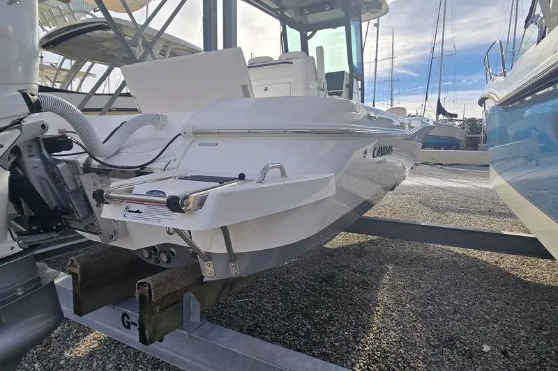Slide: The Image of 2024 Caymas 281 HB boat on trailer, rear view in marina setting. - 13