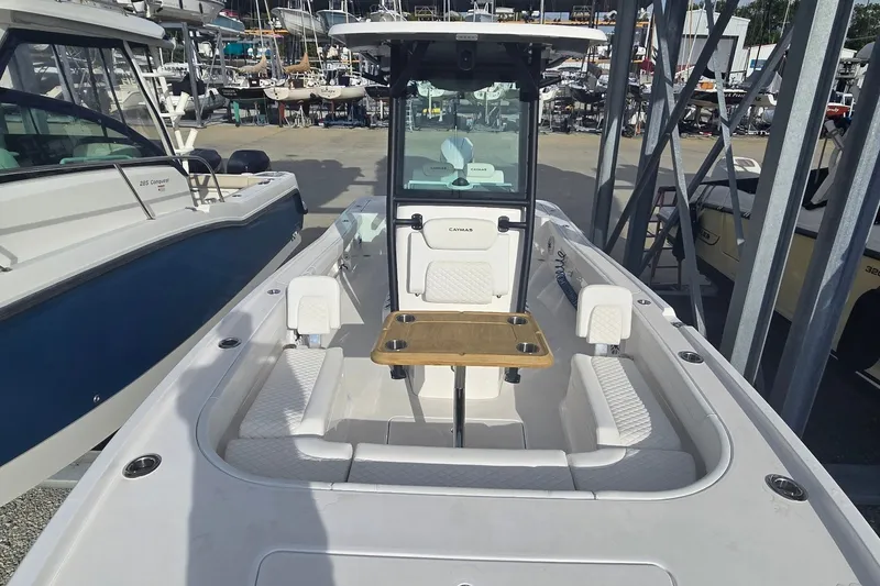 Slide: The Image of 2024 Caymas 281 HB boat interior with seating and table, docked among other boats. - 28