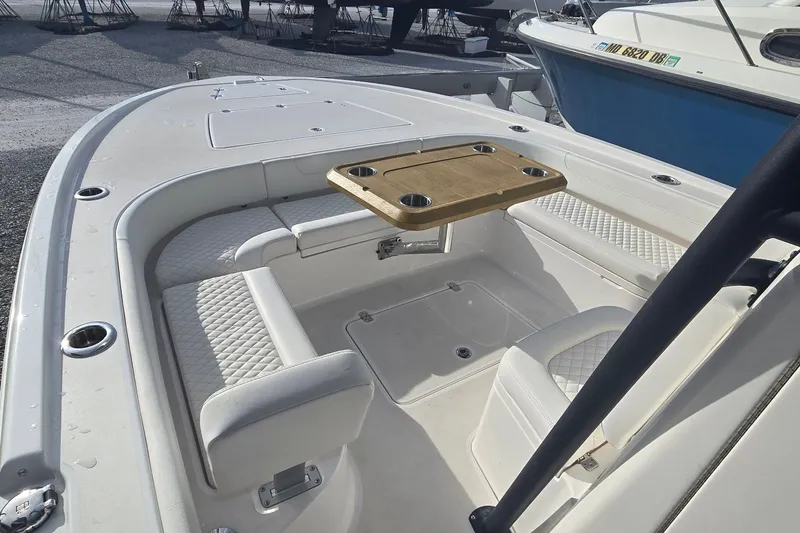 Slide: The Image of 2024 Caymas 281 HB boat interior with cushioned seating and wooden table. - 30
