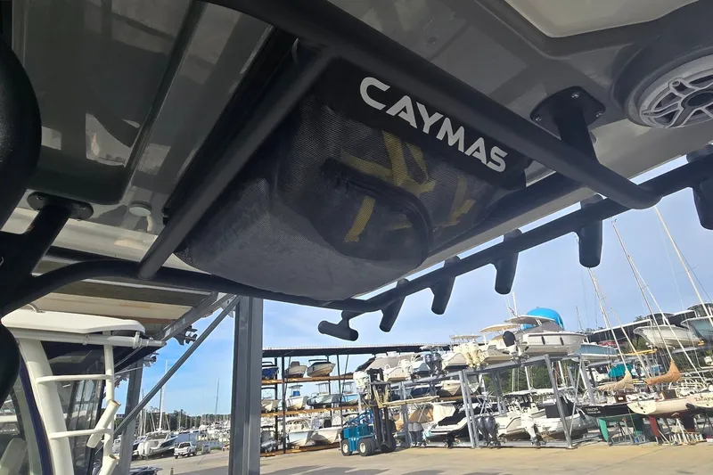 Slide: The Image of 2024 Caymas 281 HB boat with rod holders and storage, docked at a marina. - 23