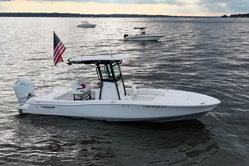 The Image of 2024 Caymas 281 HB boat on water with American flag, featuring Mercury engine. - 0