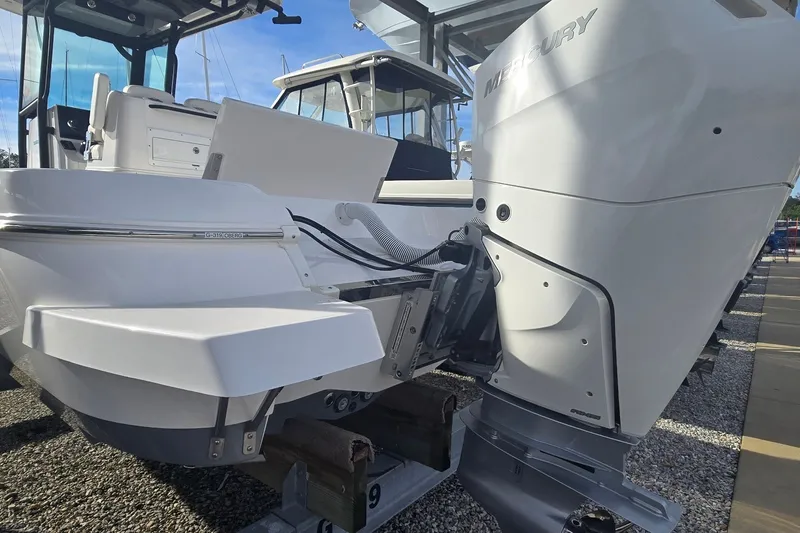 Slide: The Image of 2024 Caymas 281 HB boat with Mercury outboard engine, docked under a canopy. - 14