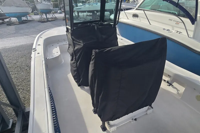Slide: The Image of 2024 Caymas 281 HB boat interior with covered seats, docked near other vessels. - 45