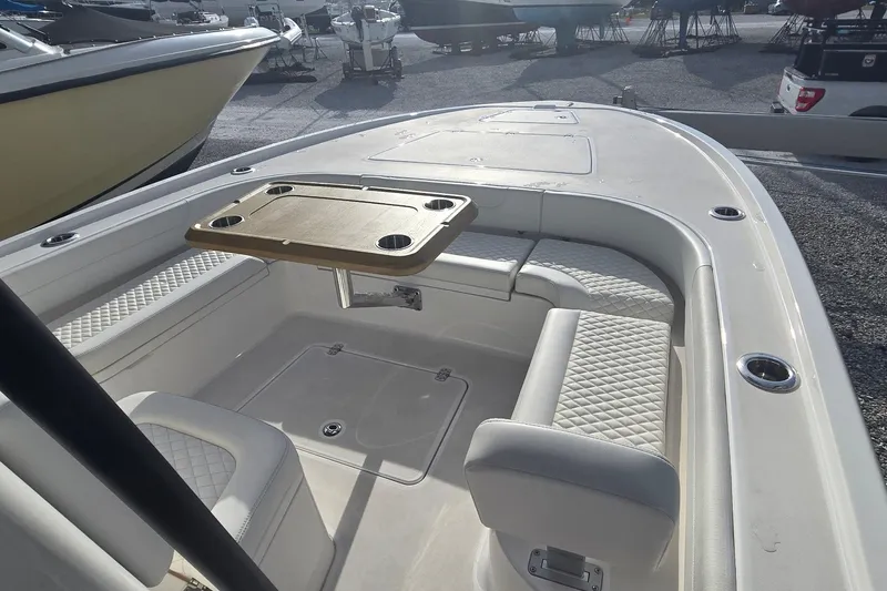 Slide: The Image of 2024 Caymas 281 HB boat interior with seating and table, docked in a marina. - 31