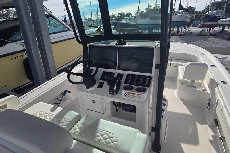 Slide: The Image of 2024 Caymas 281 HB boat cockpit with steering wheel and control panel. - 15