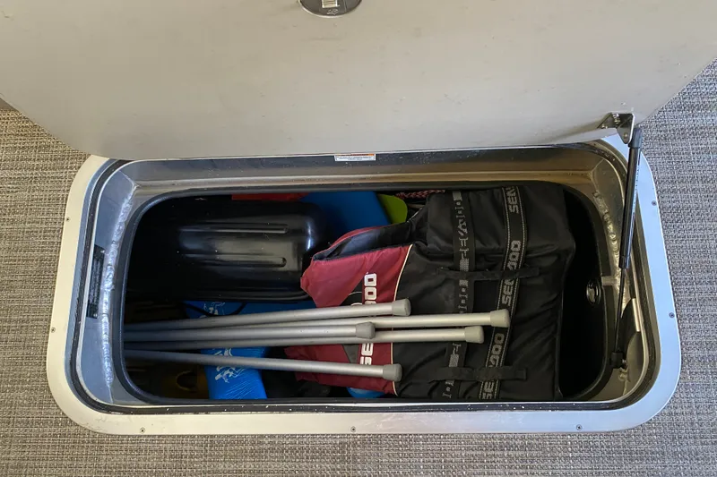 Slide: The Image of Storage compartment in 2023 Barletta Lusso 25UCA boat, containing Sea-Doo equipment and paddles. - 36