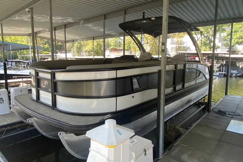 Slide: The Image of 2023 Barletta Lusso 25UCA pontoon boat docked under a covered marina. - 39