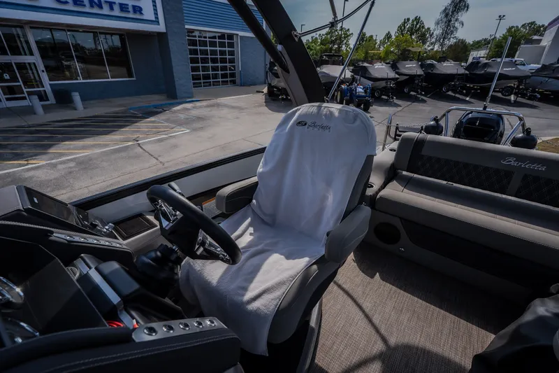 Slide: The Image of 2023 Barletta Lusso 25UCA boat interior with steering wheel and covered captain's chair. - 9