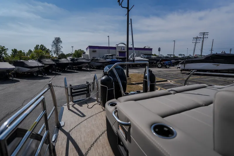 Slide: The Image of 2023 Barletta Lusso 25UCA pontoon boat in a dealership lot, surrounded by other boats. - 18