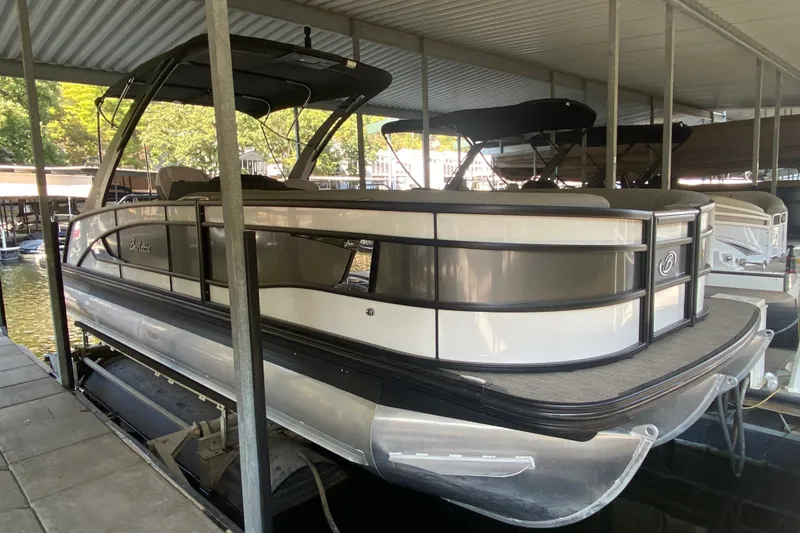 Slide: The Image of 2023 Barletta Lusso 25UCA pontoon boat docked in a covered marina. - 40