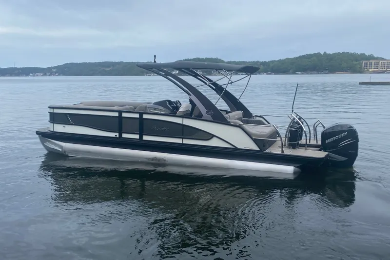 Slide: The Image of 2023 Barletta Lusso 25UCA pontoon boat on a calm lake with scenic background. - 6