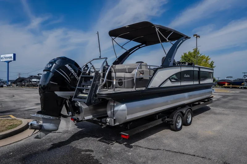 Slide: The Image of 2023 Barletta Lusso 25UCA pontoon boat with Mercury engine on trailer in parking lot. - 14
