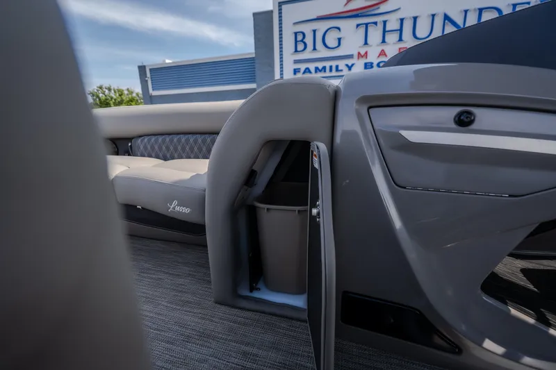 Slide: The Image of 2023 Barletta Lusso 25UCA boat interior with open storage compartment, gray seating, and "Big Thunder" sign. - 34